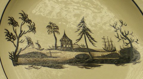 Assiette décorée d'un paysage de style chinois en camaïeu brun.