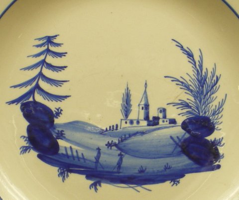 Assiette décorée d'un paysage de style chinois en camaïeu bleu.