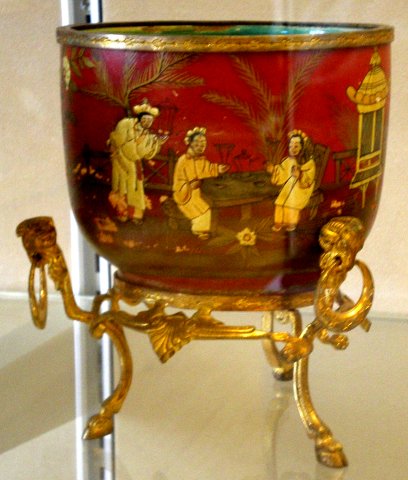 Petit cache pot à décor japonisant laqué doré sur fond rouge.