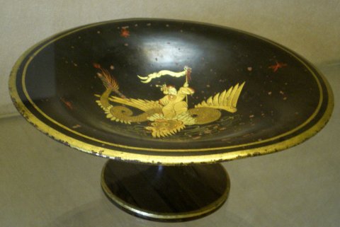 Coupe à décor japonisant or sur fond noir représentant un dragon ailé.