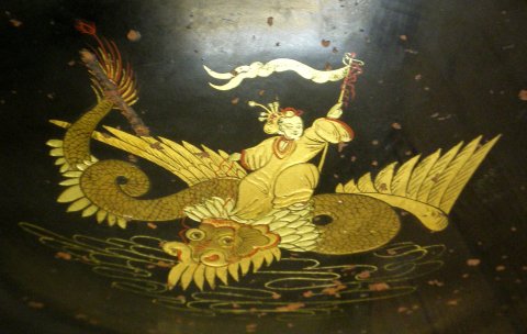 Coupe à décor japonisant or sur fond noir représentant un dragon ailé.