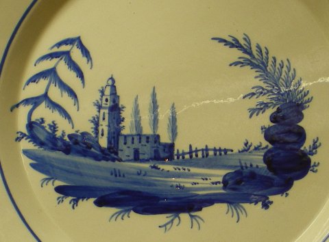 Assiette décorée d'un paysage de style chinois en camaïeu bleu.