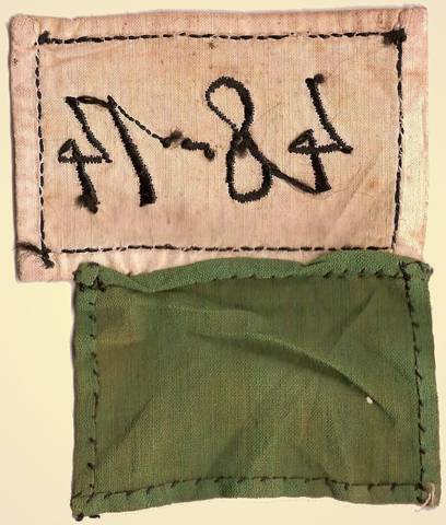 Le matricule de Mme Klinger et son carreau de tissu vert (revers).